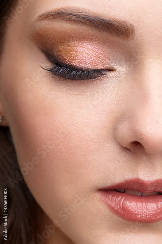 Closeup portrait of female face with red lips and smoky eyes beauty makeup.