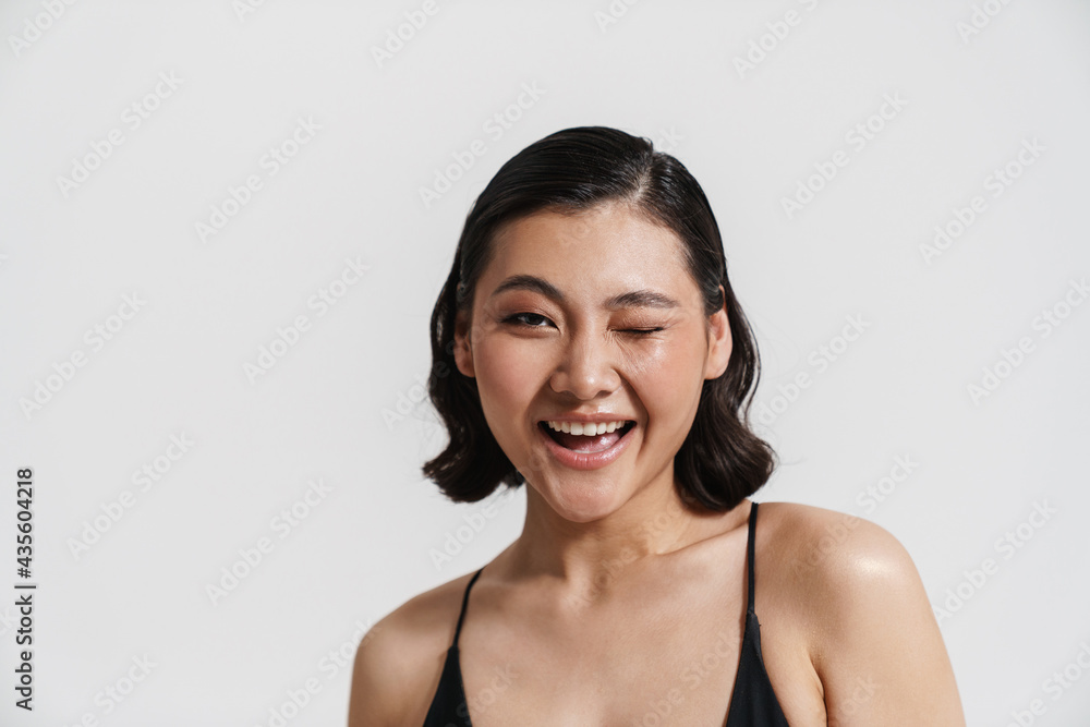 Brunette asian woman wearing swimsuit smiling and winking at camera Brunette asian woman wearing swimsuit smiling and winking at camera
