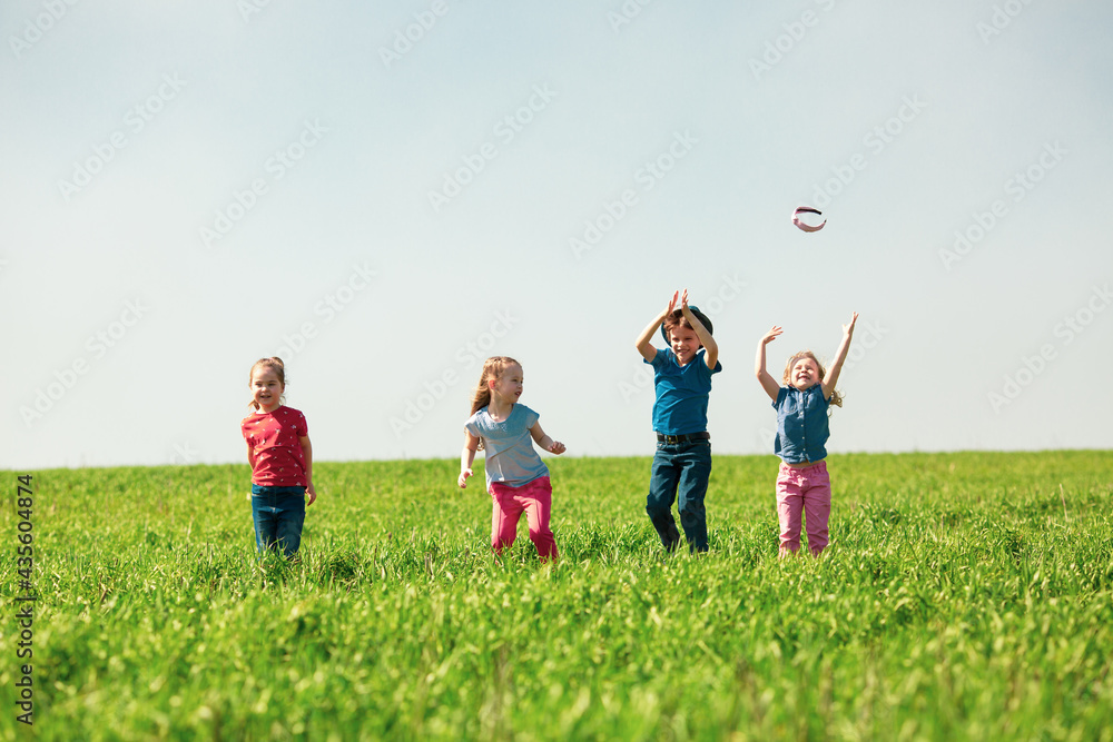 A group of happy children of boys and girls run in the Park on the grass on a Sunny summer day . The concept of ethnic friendship, peace, kindness, childhood A group of happy children of boys and girls run in the Park on the grass on a Sunny summer day . The concept of ethnic friendship, peace, kindness, childhood