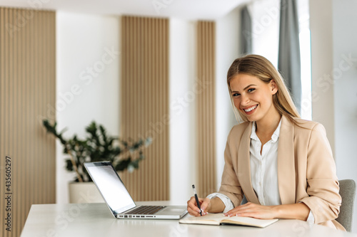 Portrait of woman, posing for camera, writing something.