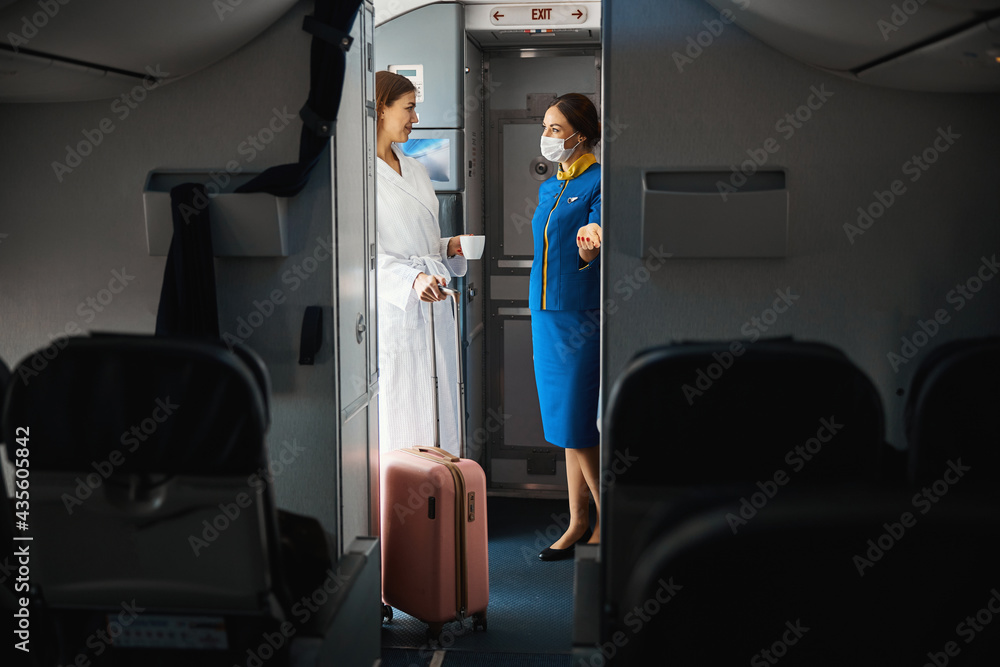 Woman with coffee in bath robe entering plane Woman with coffee in bath robe entering plane