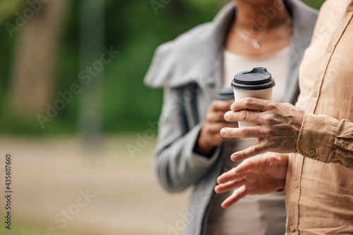 Coffee being held by an adult couple.