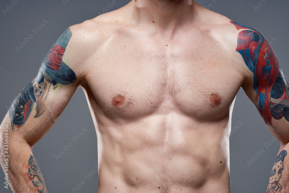 sporty man with pumped up abs tattoos on his arms gray background muscles sporty man with pumped up abs tattoos on his arms gray background muscles