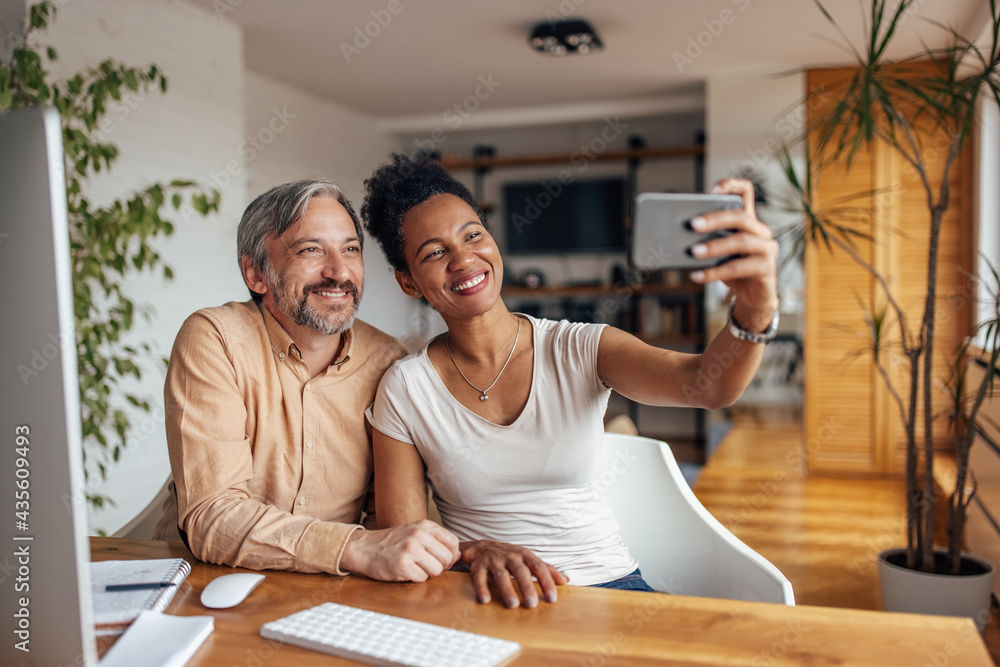 African woman, holding phone and taking a picture with her husband. African woman, holding phone and taking a picture with her husband.