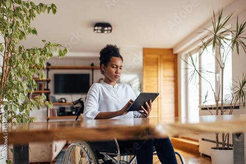 Focused disabled woman, working online, from home.
