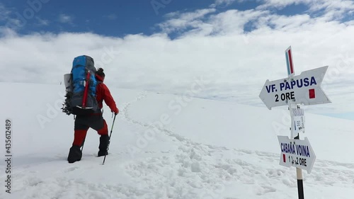 A professional snow hiker heading to Varful Papusa peak, Romania photo