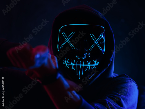 Принти на полотні A maniac in a glowing mask cuts his hand