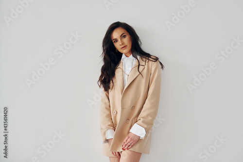 Posing in the studio. European woman in fashionable stylish clothes is indoors