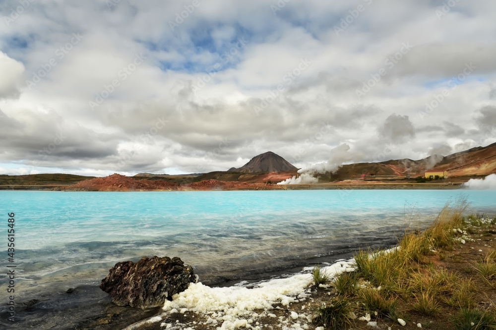 A beautiful view of the emerald waters of the Golboy Lagoon and the soaring clouds of smoke above the water. Iceland. 