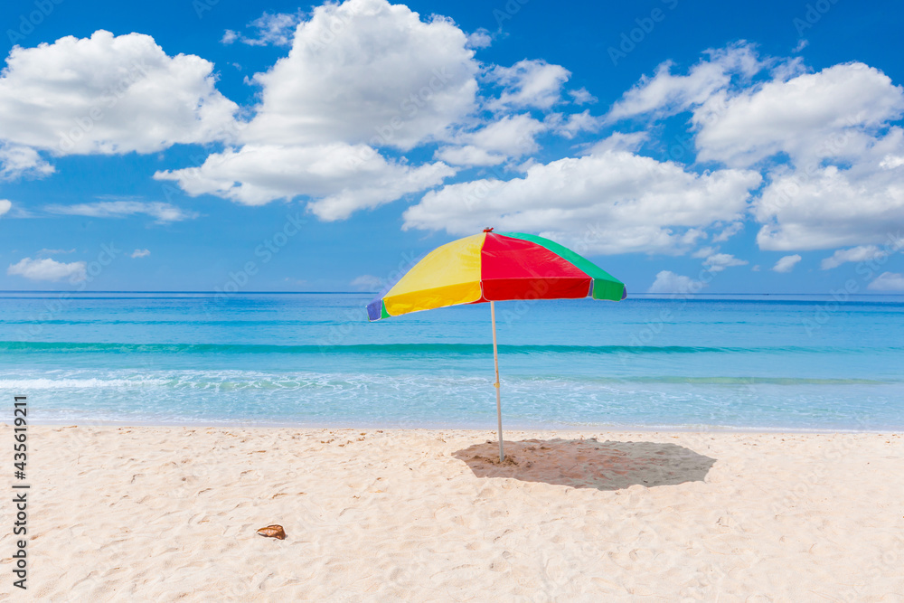 A colourful umbrella on white beach.