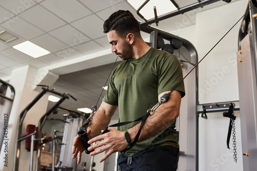 Εκτύπωση καμβά Muscular bearded handsome guy doing chest cable crossover exercise