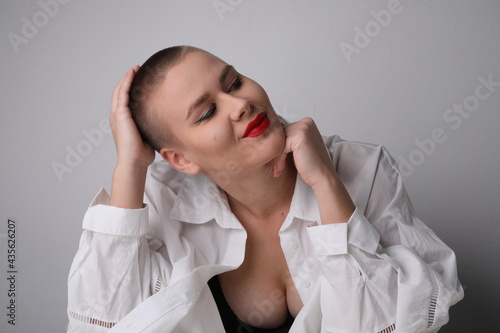 Happy young bald woman, posing in the studio. Isolated. photo