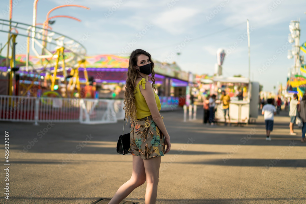 Mujer atractiva en vestido de verano pasando el tiempo en el parque de atracciones