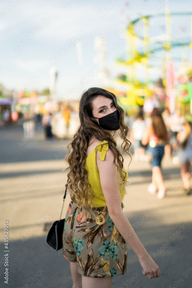 Mujer atractiva en vestido de verano pasando el tiempo en el parque de atracciones Mujer atractiva en vestido de verano pasando el tiempo en el parque de atracciones