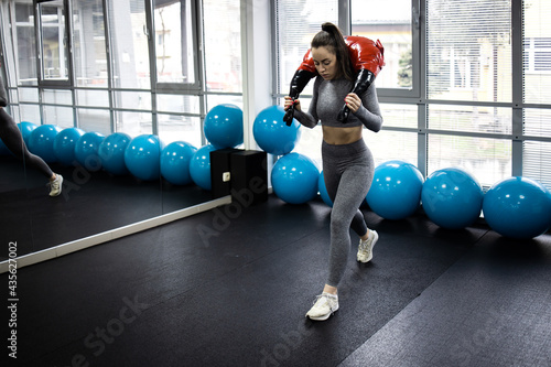 Young female athlete work out in gym performing legs exercises.