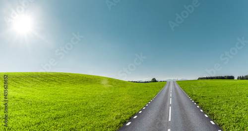 Strasse durch grüne Hügellandschaft