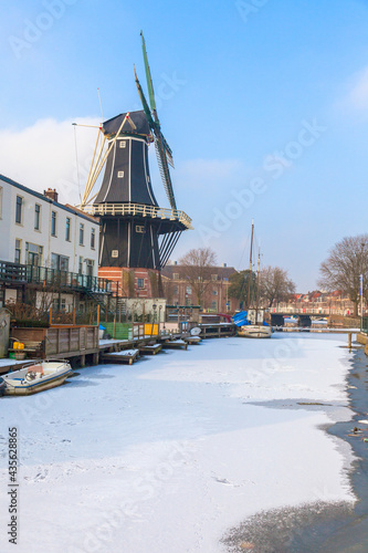 Windmill De Adriaan along the frozen canal of Spaarne river, Haarlem, Amsterdam district, North Holland, The Netherlands photo