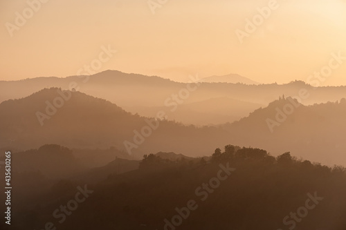 Sunset light reflected in the mist on countryside hills, Emilia Romagna, Italy photo