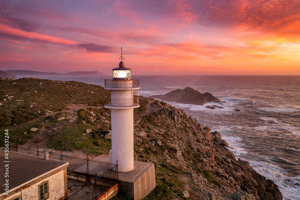 Aerial sea landscape view of Cape Tourinan Lighthouse at sunset with pink clouds, Galicia