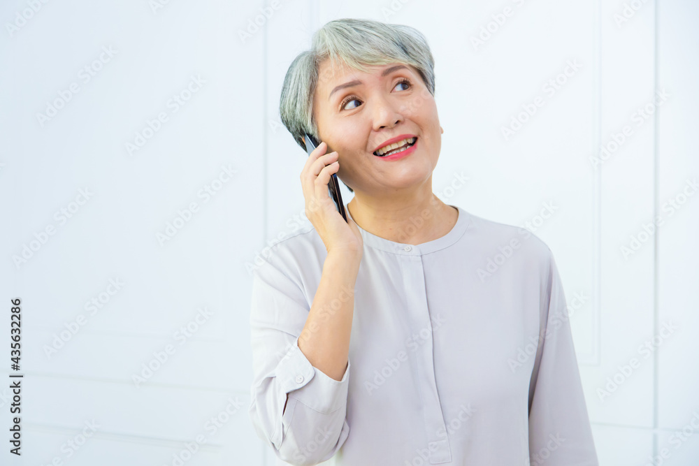 Senior Asia woman is talking on her mobile phone. Senior woman has a happy conversation at cellphone. Senior Asia woman is talking on her mobile phone. Senior woman has a happy conversation at cellphone.