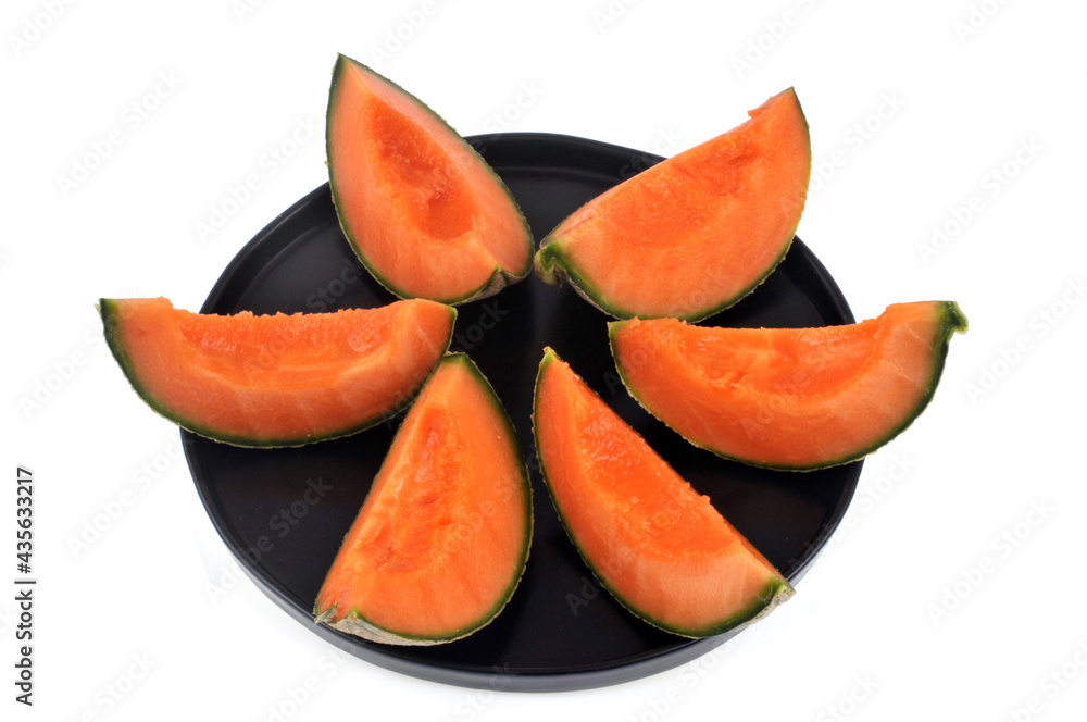 Melon coupé en tranches dans une assiette en gros plan sur fond blanc vu de dessus Melon coupé en tranches dans une assiette en gros plan sur fond blanc vu de dessus