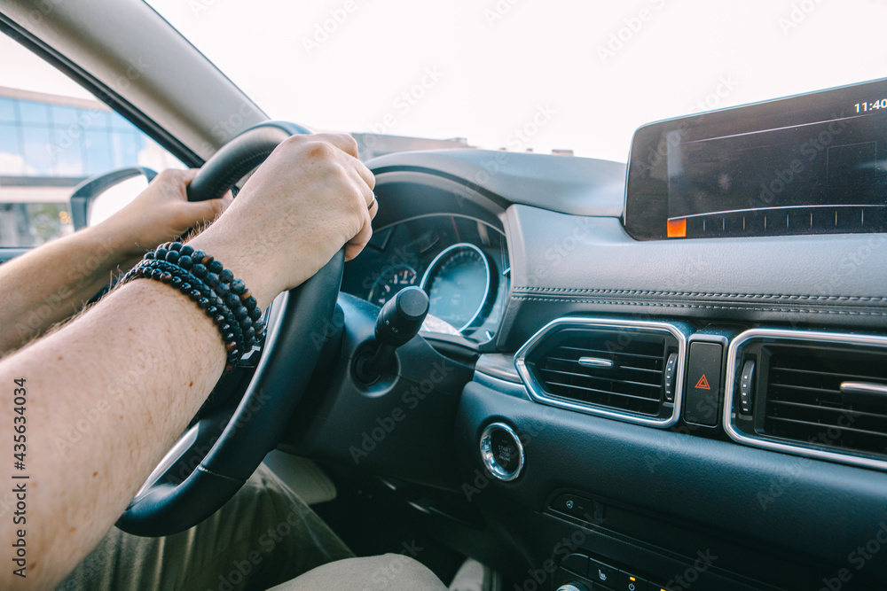 man hands on steering wheel