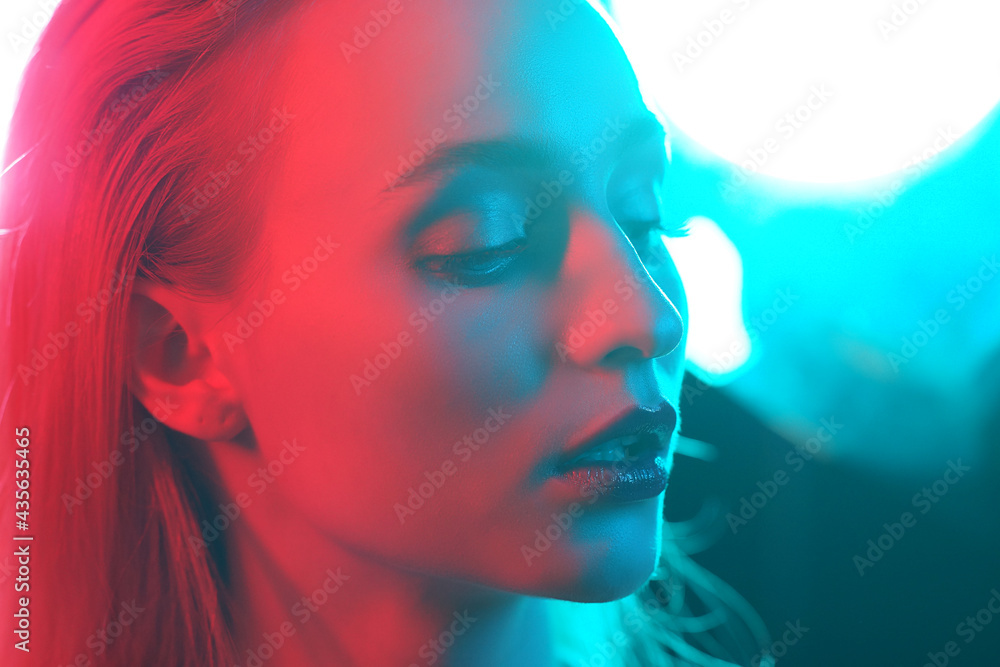 Portrait of a beautiful and young girl in cyberpunk style. Mixed color light effect. Futuristic concept. Portrait of a beautiful and young girl in cyberpunk style. Mixed color light effect. Futuristic concept.