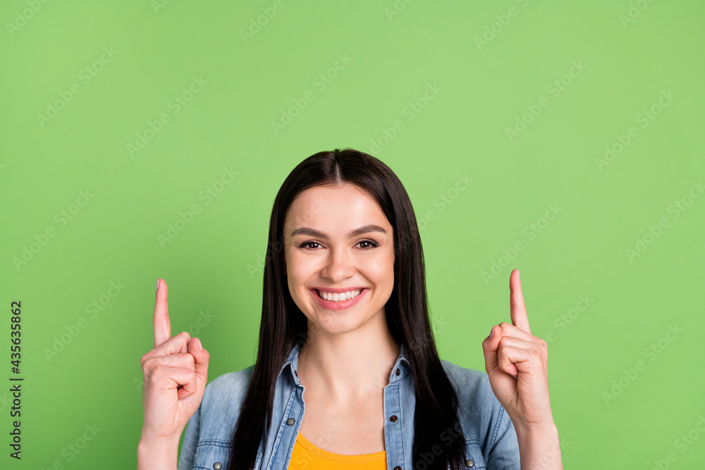 Photo of cheerful nice brown long hairdo lady point empty space wear jeans shirt isolated on pastel green color background Photo of cheerful nice brown long hairdo lady point empty space wear jeans shirt isolated on pastel green color background
