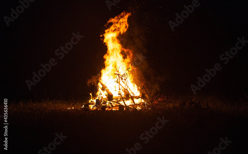 Big beautiful bonfire in the night forest in the holiday bath. Tourism and recreation in the forest against the background of the night sky, copy space