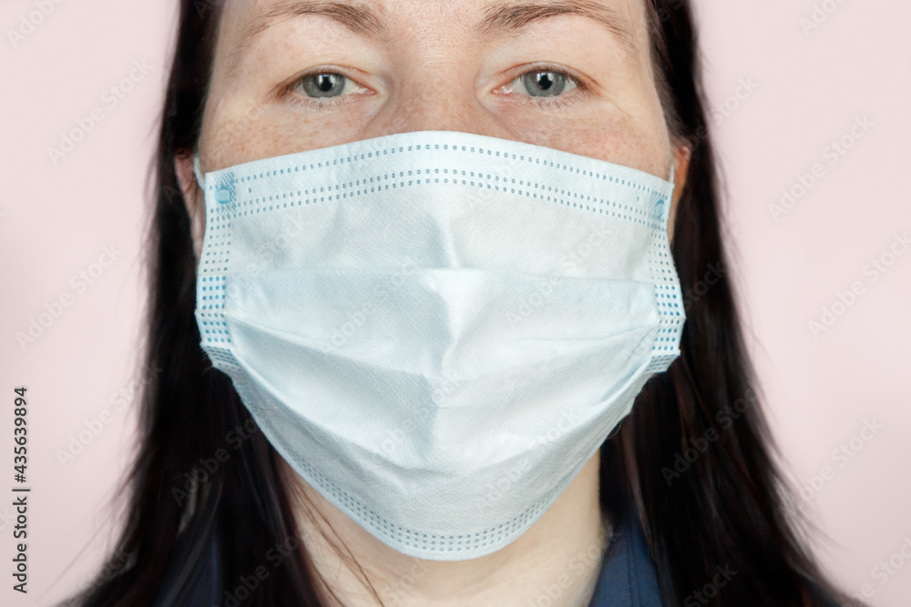 Portrait of an adult woman wearing a medical face mask protecting against respiratory diseases transmitted by airborne droplets such as coronavirus and flu Portrait of an adult woman wearing a medical face mask protecting against respiratory diseases transmitted by airborne droplets such as coronavirus and flu