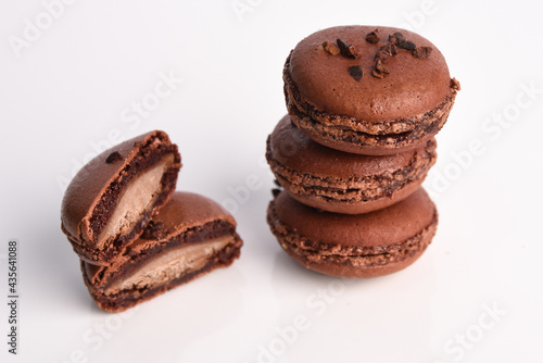 Brown macaroon with filling on a white background.