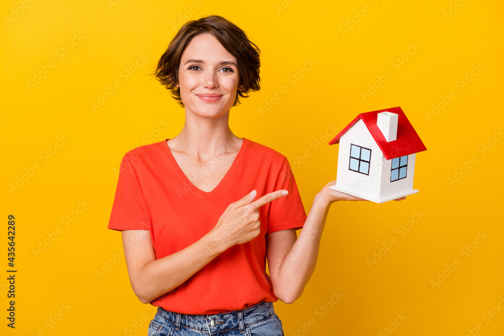 Photo of optimistic nice brunette lady point home wear orange t-shirt isolated on yellow background Photo of optimistic nice brunette lady point home wear orange t-shirt isolated on yellow background