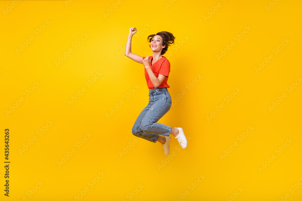 Full size profile photo of hooray brunette short hairdo lady jump wear t-shirt jeans sneakers isolated on yellow color background Full size profile photo of hooray brunette short hairdo lady jump wear t-shirt jeans sneakers isolated on yellow color background