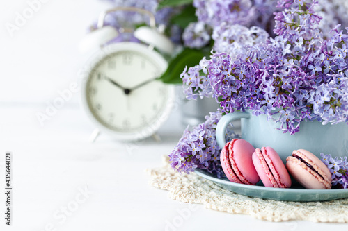 Postcard with violet lilac bouquet in a blue cup and delicious french macarons. Template for birthday card, greeting for Mother's Day, Saint Valentine's day, 8 March, Women's Day. White background