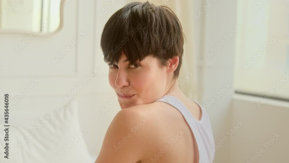 Young sensual woman with short hair flirting eyes looking at the camera and smiling in bedroom. Healthy skin care. Young sensual woman with short hair flirting eyes looking at the camera and smiling in bedroom. Healthy skin care.