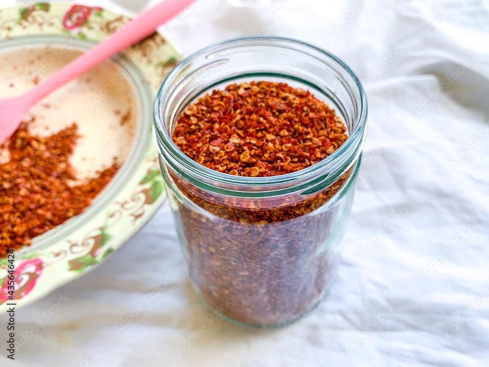 spicey red chilli pepper flakes in a glass jar with soft focus image. spicey red chilli pepper flakes in a glass jar with soft focus image.