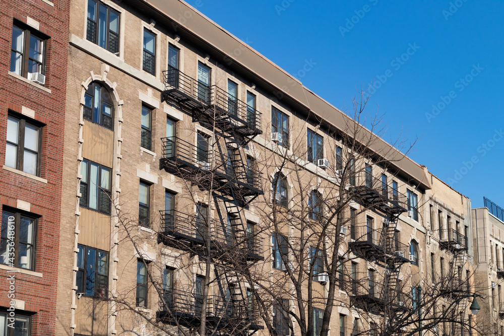 Row of Old Apartment Buildings with Fire Escapes in Harlem of New York City