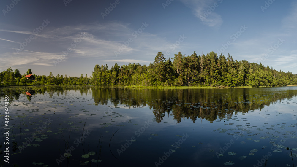 Beautiful evening view with lake, reflections in the water and clouds.