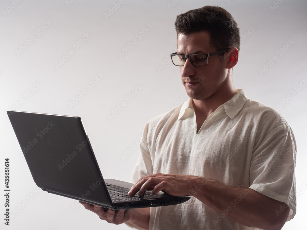 man laptop with glasses. Computer master on light background. Focused Computer master with laptop. Concept - he sets up software on laptop. Computer master or system administrator work. man laptop with glasses. Computer master on light background. Focused Computer master with laptop. Concept - he sets up software on laptop. Computer master or system administrator work.