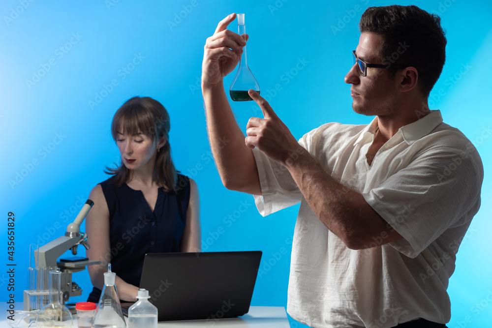 Bio Lab Assistant Microbiologist in laboratory. Two young scientists are studying biology ...