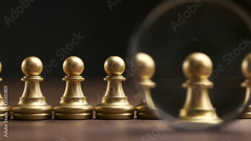 The concept of recruiting and searching personnel for work from chess pieces and a magnifying glass.