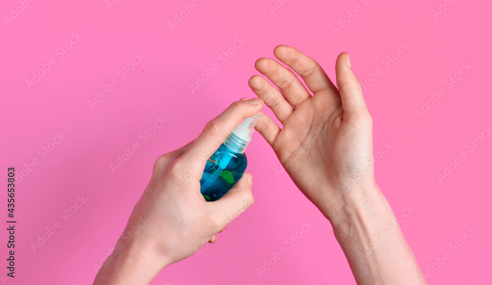 Hand disinfection with antiseptic on pink background Hand disinfection with antiseptic on pink background