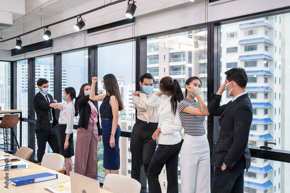Group of multi ethnic business coworker wearing face mask greeting with elbow bump in new normal office Group of multi ethnic business coworker wearing face mask greeting with elbow bump in new normal office