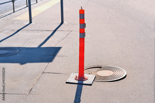 Traffic cones sign in front of a broken sewer hatch
