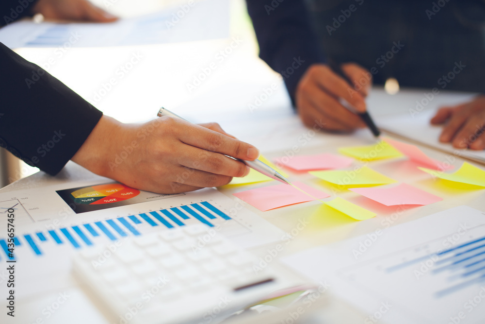 Business people use charts and graphs showing the results of successful teamwork in the office. Using graph sheets and tablets to work Business people use charts and graphs showing the results of successful teamwork in the office. Using graph sheets and tablets to work