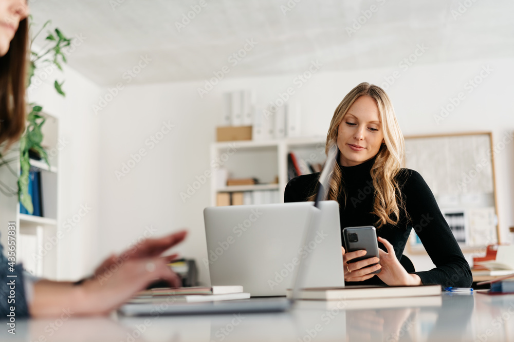 Low angle view of a young businesswoman working at a laptop Low angle view of a young businesswoman working at a laptop