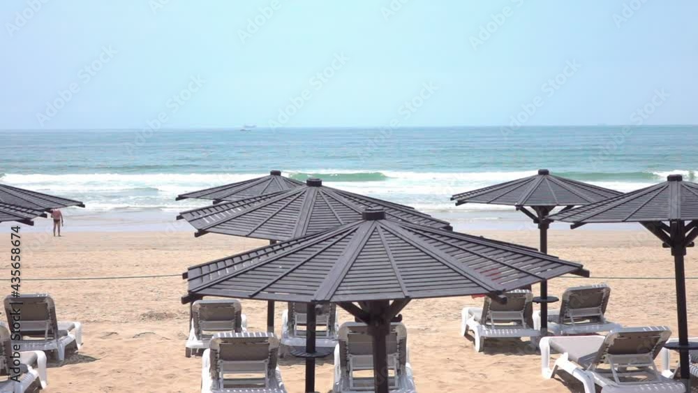 Beach sunbeds and umbrellas on the empty closed beach during pandemic time in slow motion 250fps Beach sunbeds and umbrellas on the empty closed beach during pandemic time in slow motion 250fps