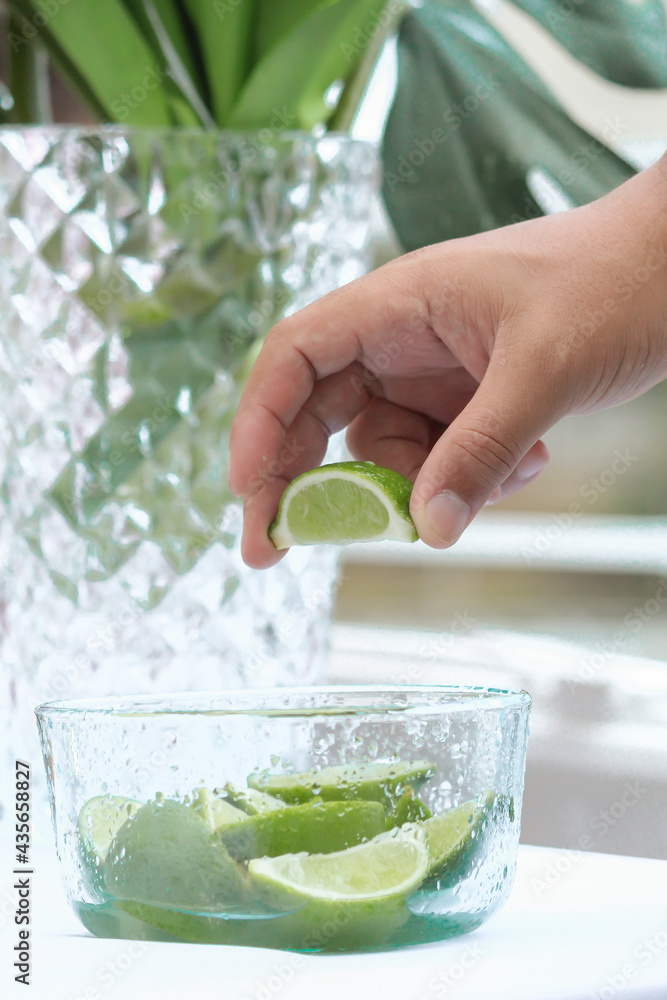 una persona exprime un limón de una pequeña jarra con limones cortados, fruta ácida 素材庫相片 una persona exprime un limón de una pequeña jarra con limones cortados, fruta ácida 素材庫相片
