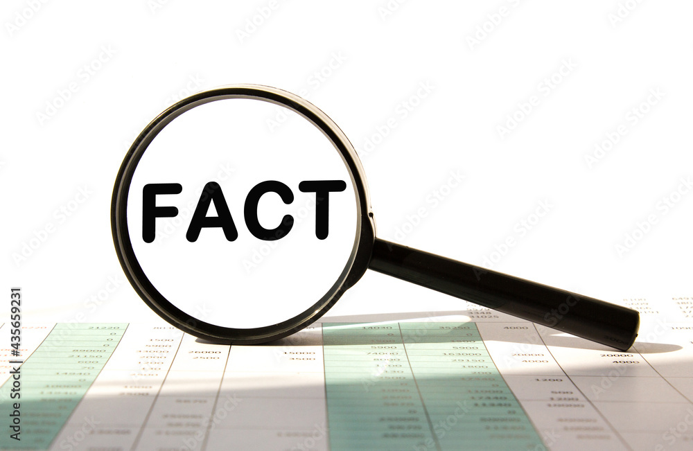 FACT.magnifying glass against the background of the desk with documents ...