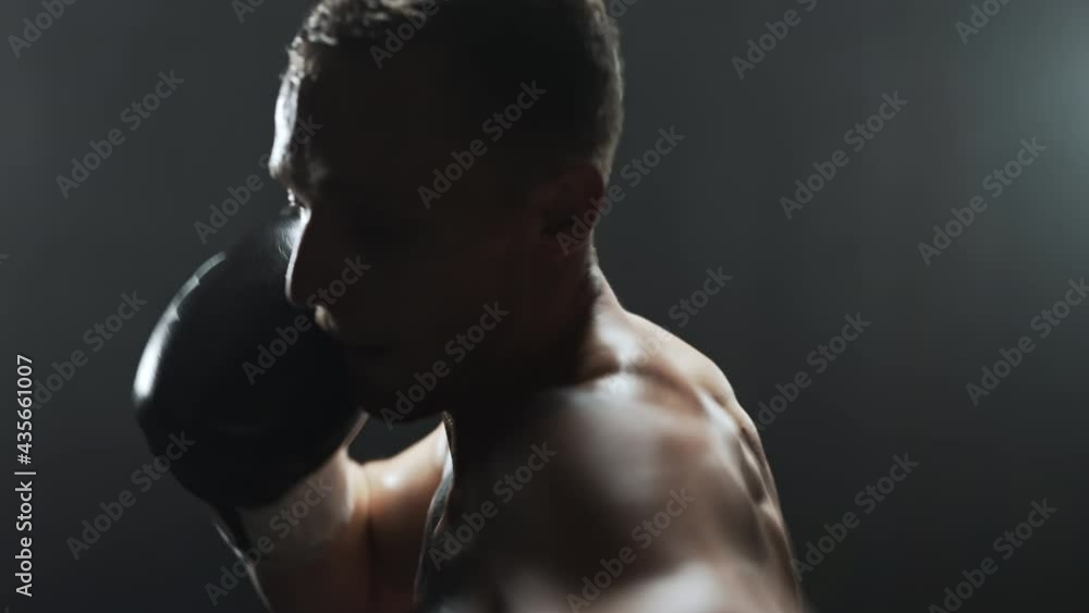 Boxer catching a breath before continuing training with a boxing bag. Boxer catching a breath before continuing training with a boxing bag.